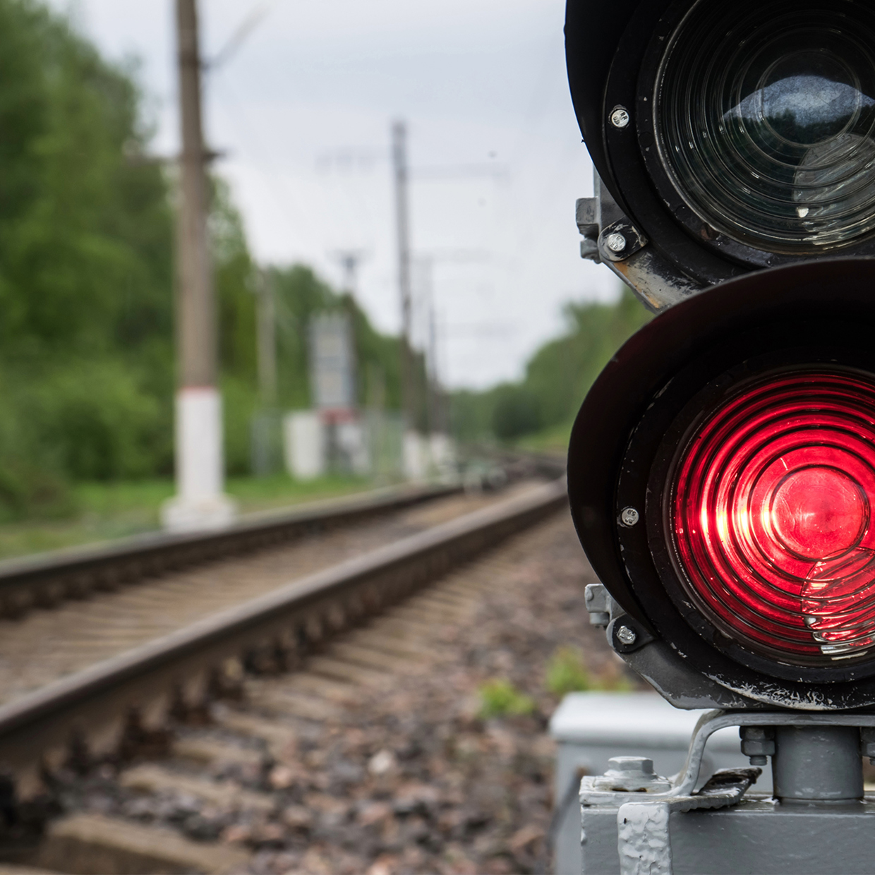 Feu rouge avec des rails de chemin de fer en arrière-plan